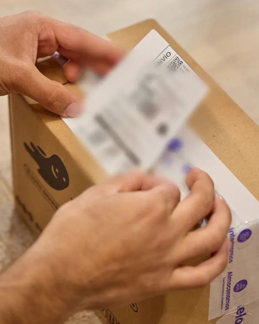 Operario de Melonn pega la etiqueta de envío sobre una caja de la marca ya sellada